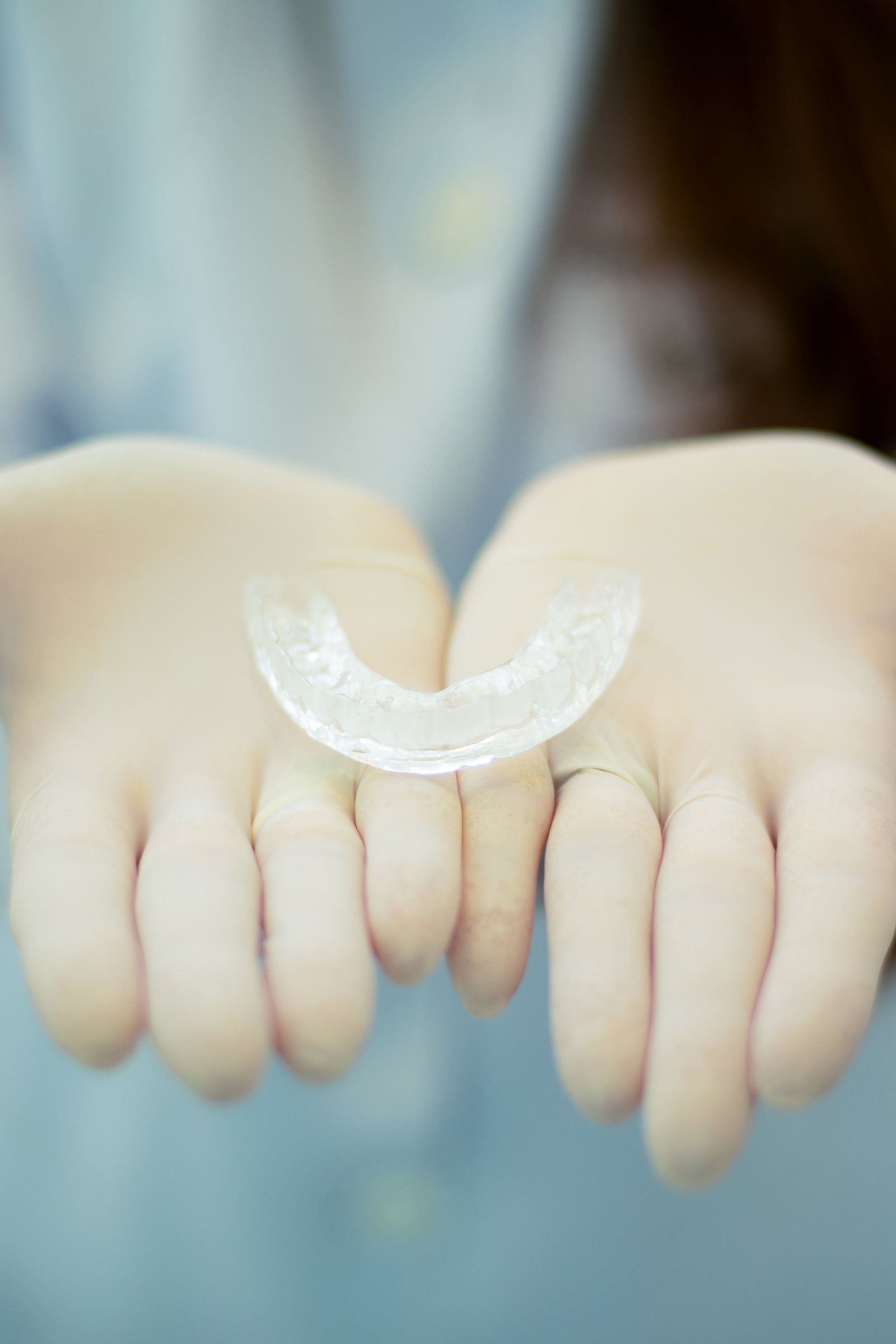 Alineador dental transparente sobre las manos de un profesional